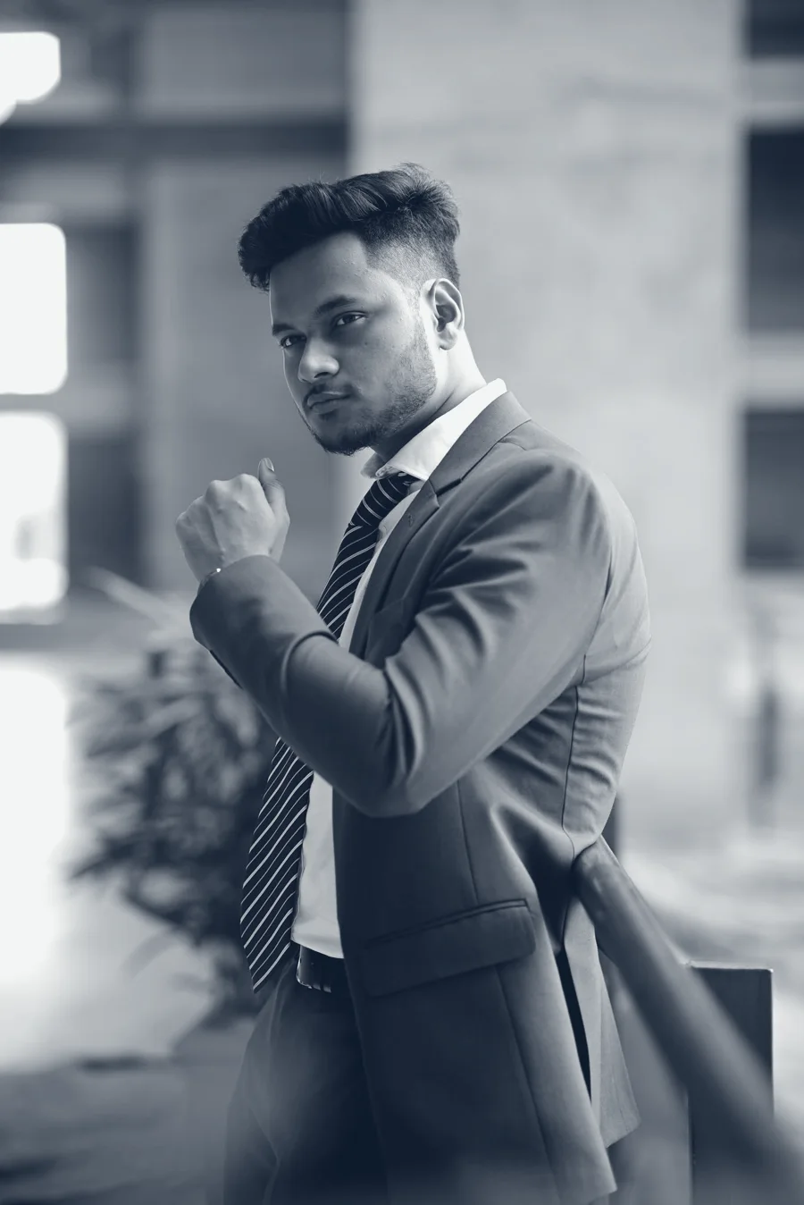 Motammim Haque Rabib in a suit, leaning on a railing