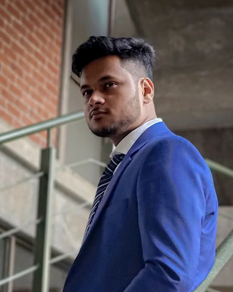 Motammim Haque Rabib in a blue suit on a concrete staircase